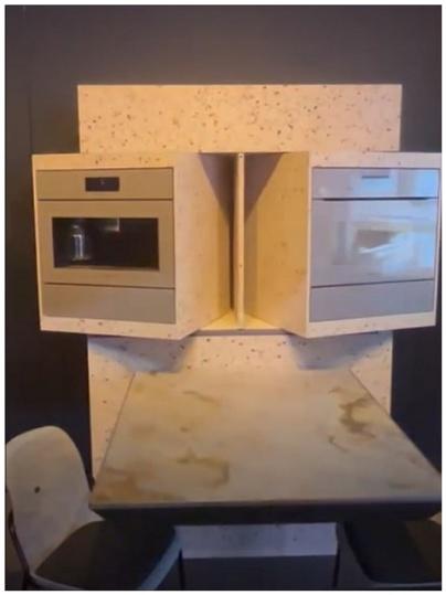Miele-Prototyp: Schrank mit schwenkbarer Mikrowelle und schwenkbarem Ofen über einem Tisch
